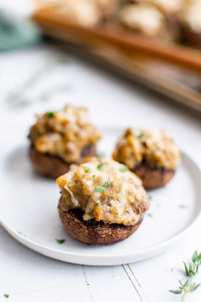 Three stuffed mushrooms on a plate.