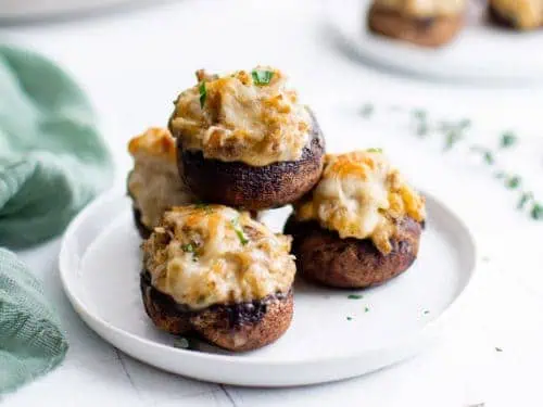 Mushrooms on a plate next to a green towel.