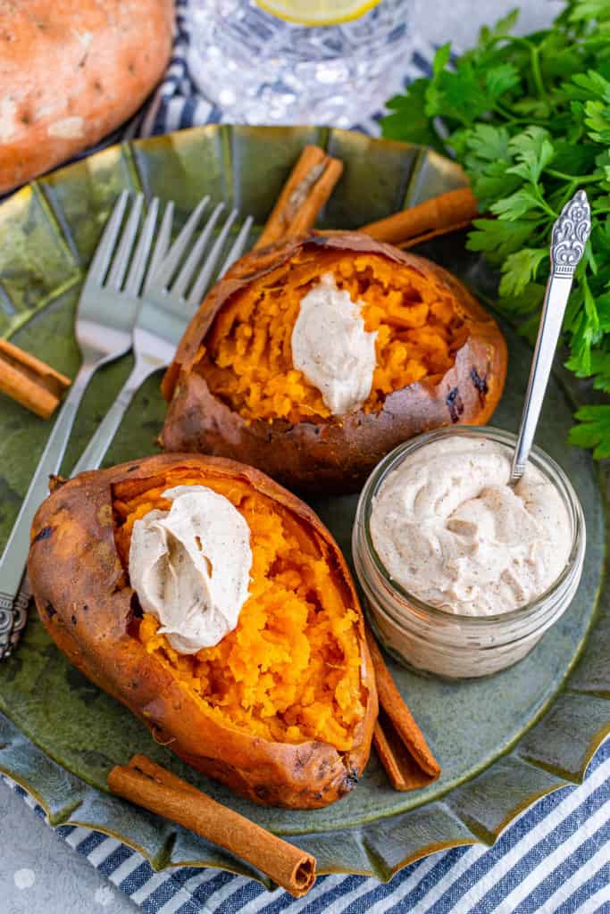 Top down view of a jar of cinnamon butter next to sweet potatoes.