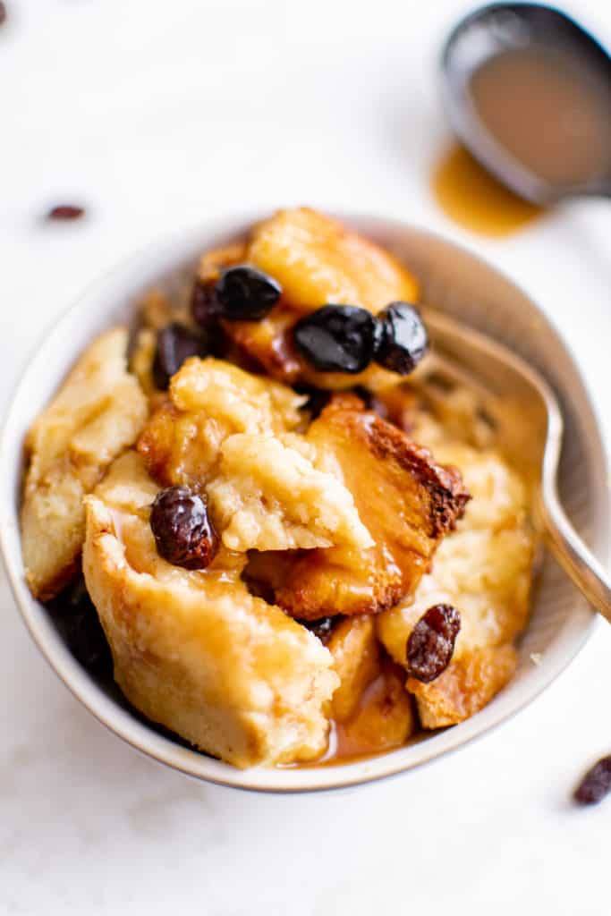 Caramel bread pudding with raisins in a bowl.