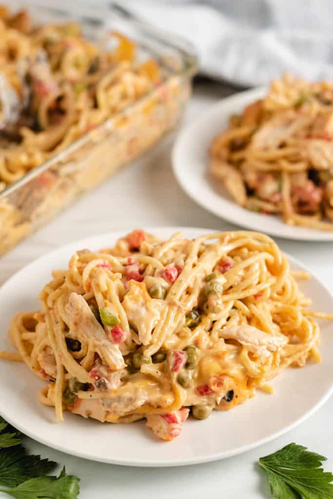 Two white plates loaded with chicken spaghetti.
