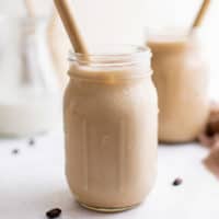 Mason jars filled with iced shaken espresso with straws.