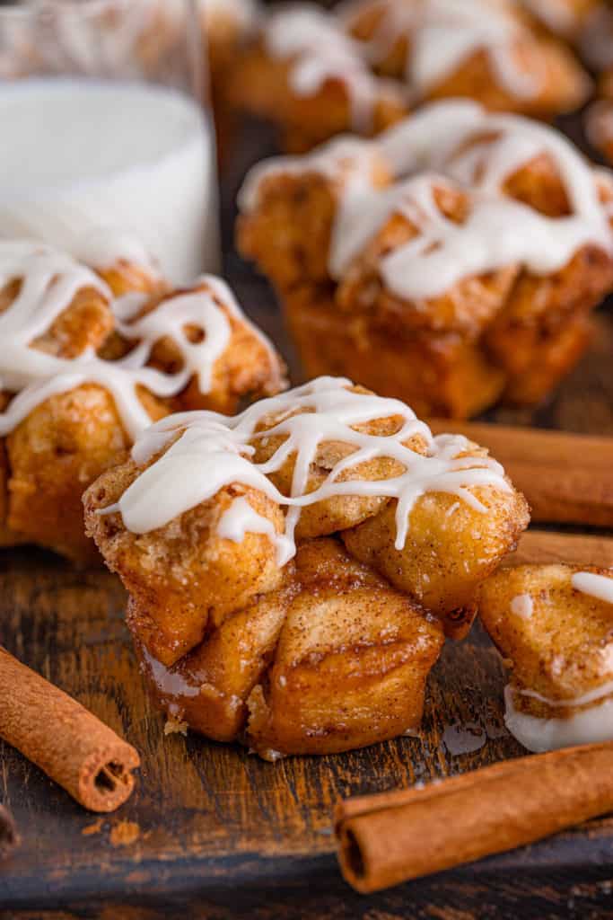 Monkey bread muffin next to a cinnamon stick.