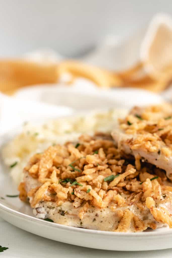 Two pork chops with sauce on a plate.