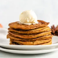 Pumpkin pancake stack with a scoop of butter.