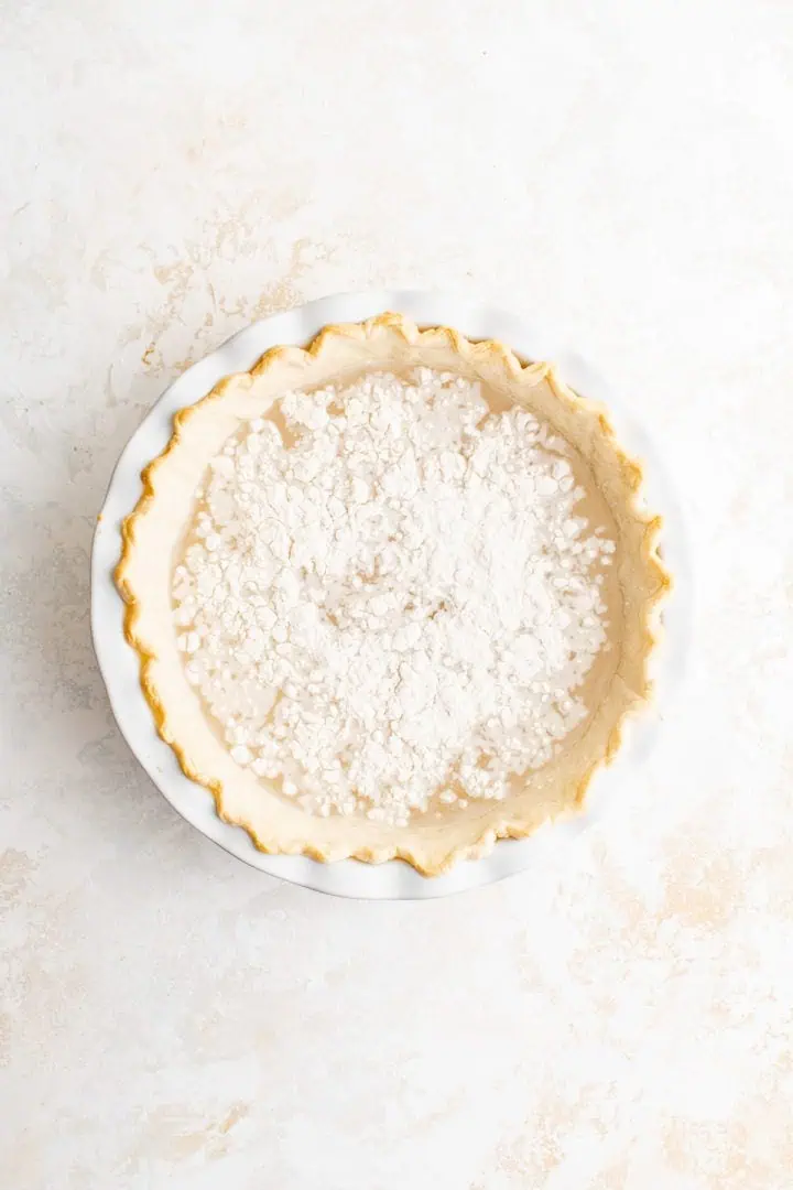Top down view of flour sprinkled over water in a pie.