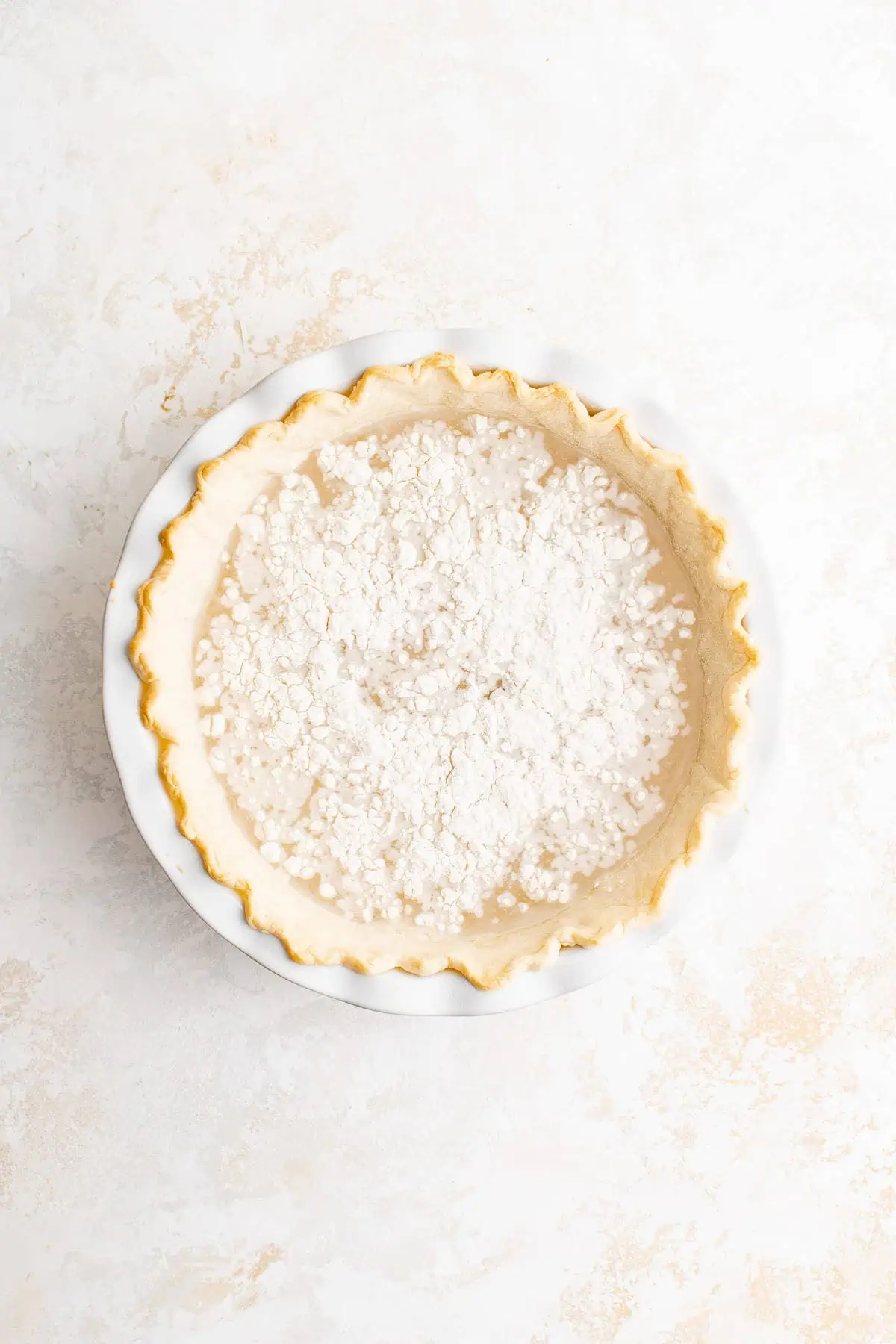 Top down view of flour sprinkled over water in a pie.