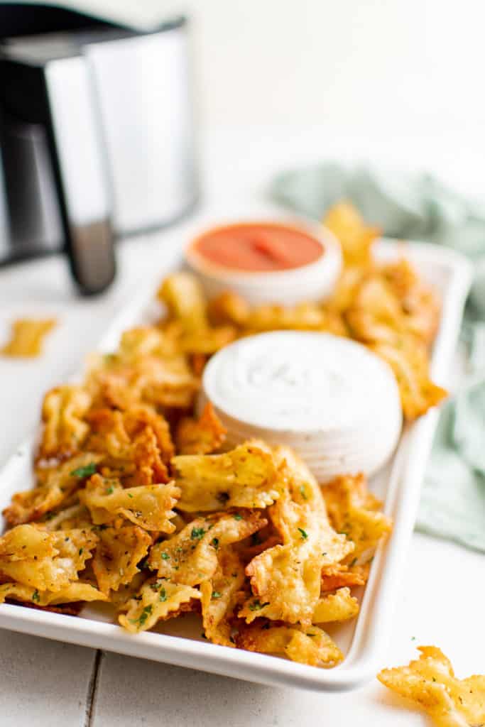 White platter filled with air fryer pasta chips and sauce.