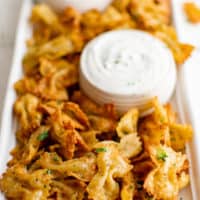 Large plate of pasta chips with ranch dressing.