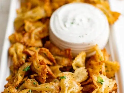 Large plate of pasta chips with ranch dressing.
