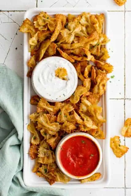 Platter of air fryer pasta chips with dipping sauces.