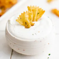 Bowl of ranch with two pasta chips.