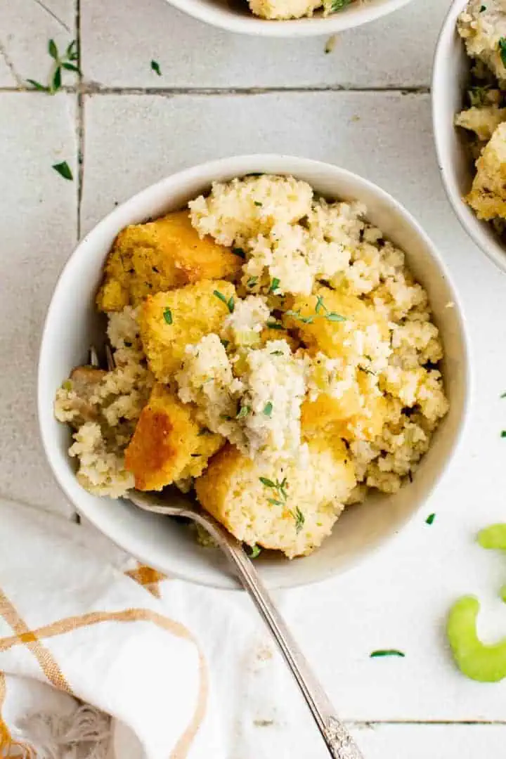 Southern Cornbread Dressing Recipe Top down view of cornbread stuffing in a white bowl.