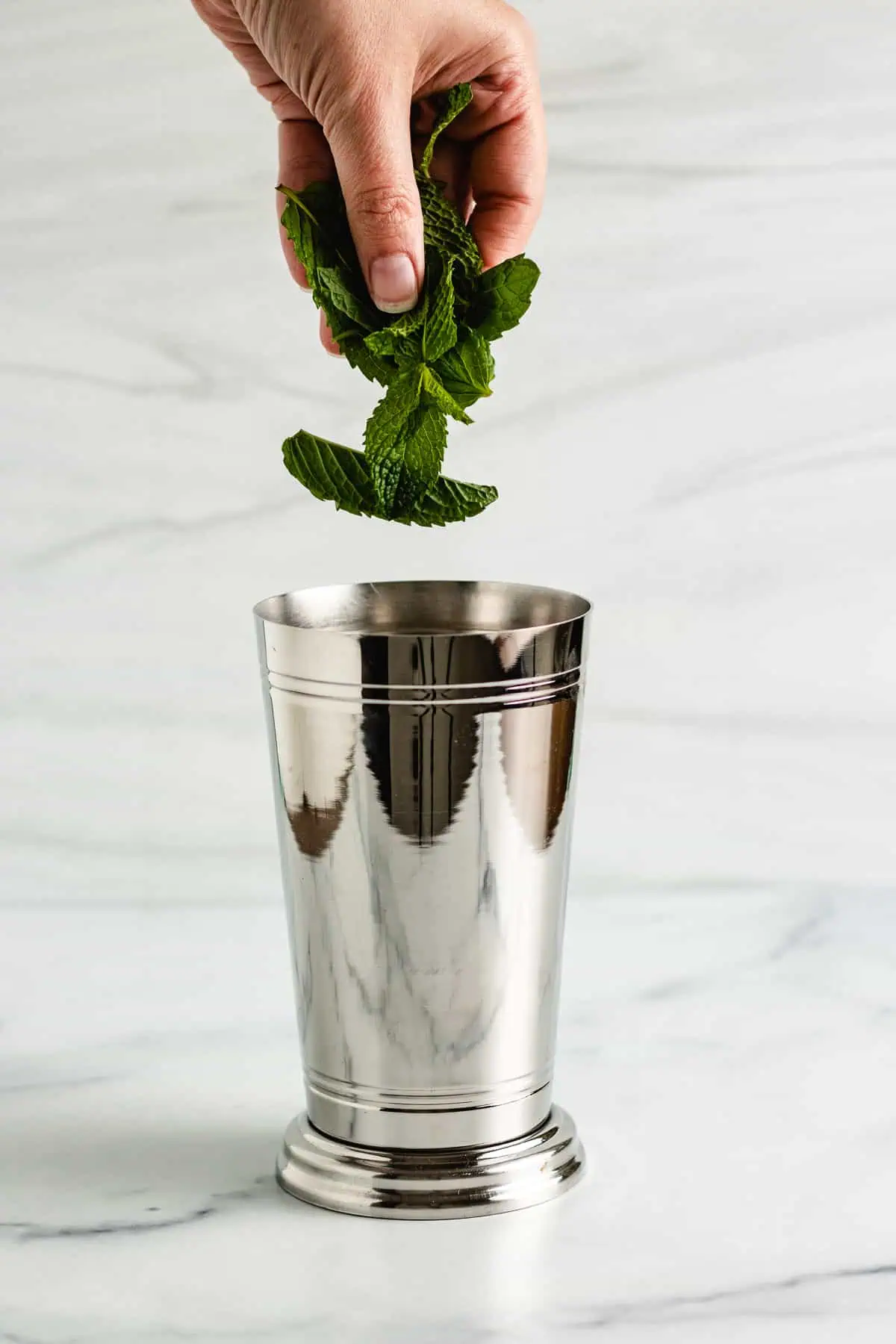 Mint being dropped into a shaker.