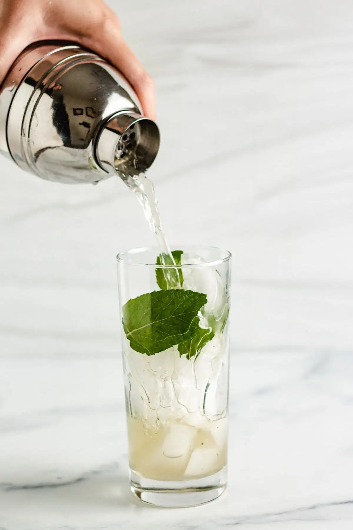 Mojito being poured into a glass.