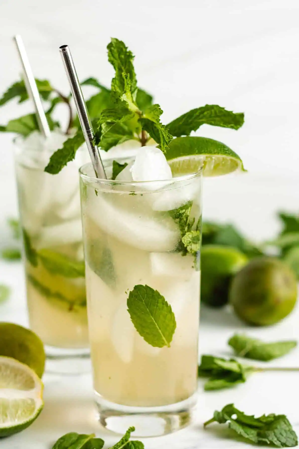 Glasses of our classic mojito recipe with fresh mint leaves and lime.