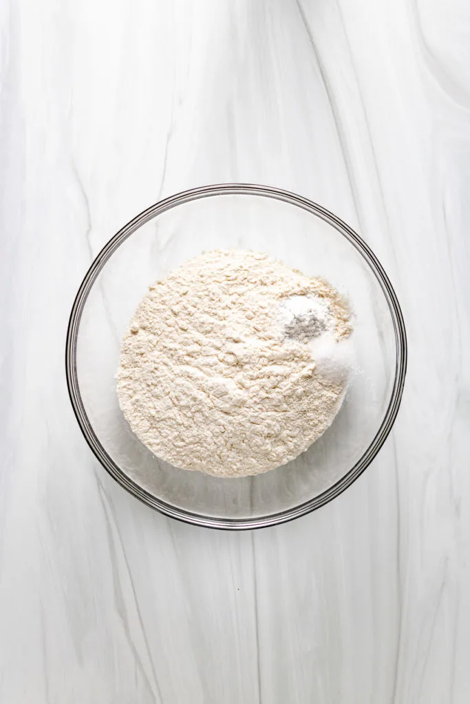 Top down view of flour, baking powder, and salt in a bowl.