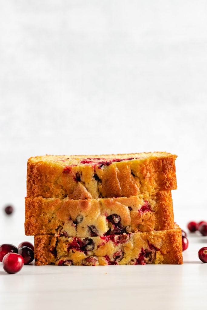 Stack of three pieces of cranberry orange bread.