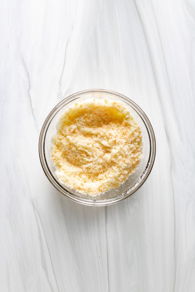 Top down view or orange sugar in a bowl.