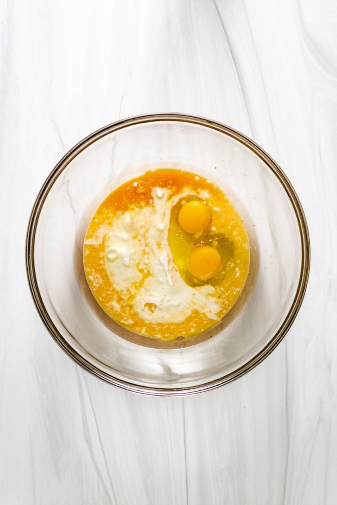 Top down view of buttermilk, oil, and eggs in a bowl.