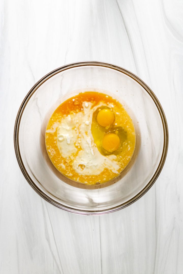 Best Orange Cranberry Bread Top down view of buttermilk, oil, and eggs in a bowl.