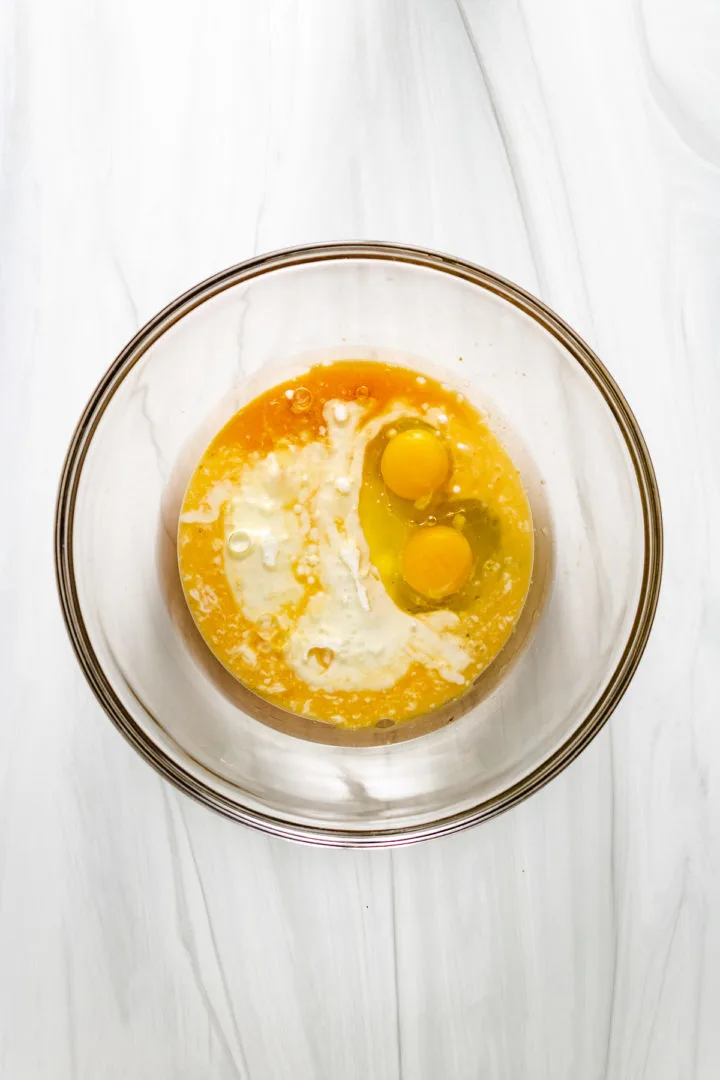 Top down view of buttermilk, oil, and eggs in a bowl.