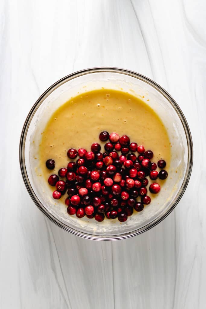 Top down view of bread batter with fresh cranberries.