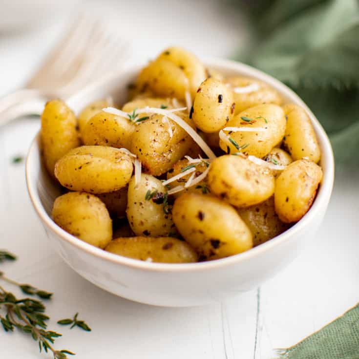 White bowl filled with pan fried gnocchi.