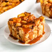 Top down view of pumpkin bread pudding with caramel on a serving dish.