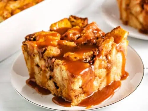 Top down view of pumpkin bread pudding with caramel on a serving dish.