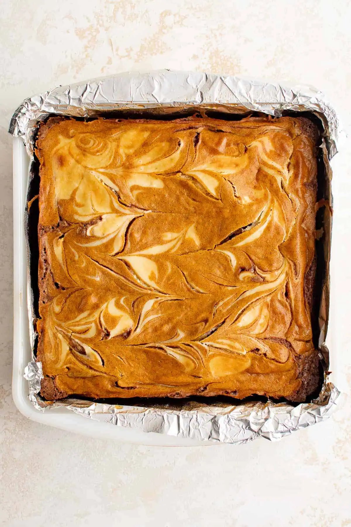Top down view of uncut pumpkin brownies in a pan.