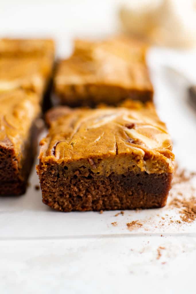 Several brownies sliced and sitting on parchment.