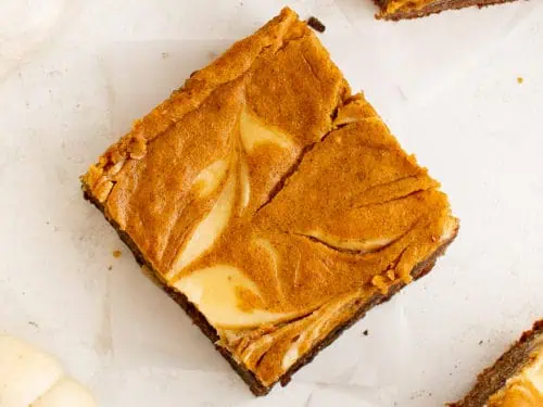 Top down view of cream cheese swirled in a pumpkin brownie.
