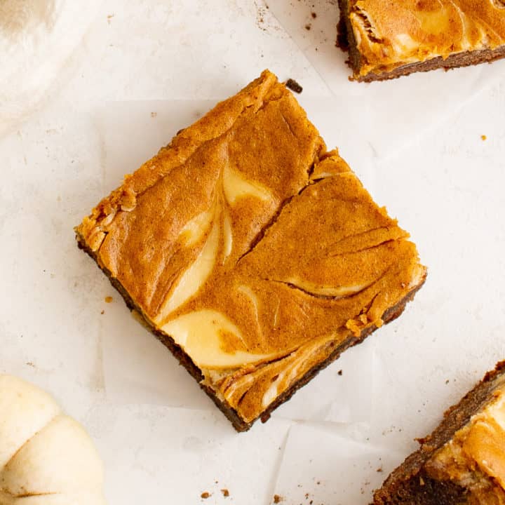 Top down view of cream cheese swirled in a pumpkin brownie.