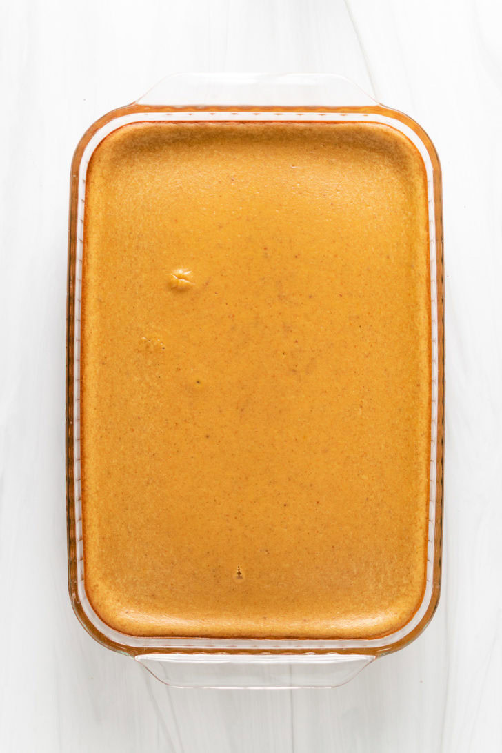 Top down view of baked cheesecake bars in a pan.