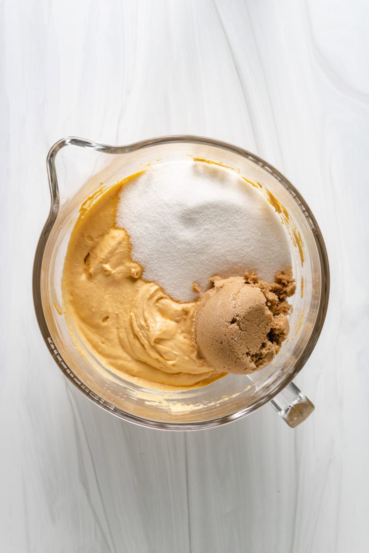 Top down view of sugars on top of pumpkin cream cheese mixture in a bowl.