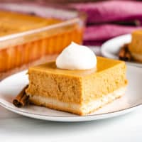 Square piece of pumpkin cheesecake on a plate.