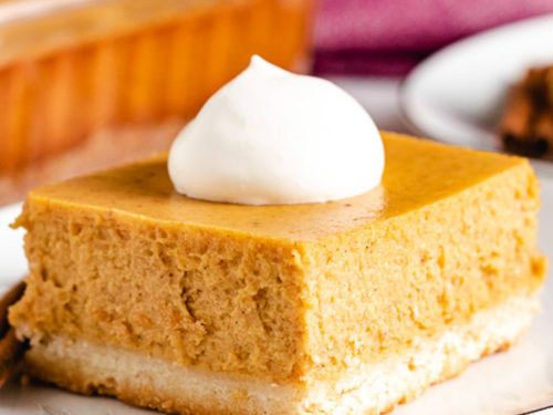 Square piece of pumpkin cheesecake on a plate.