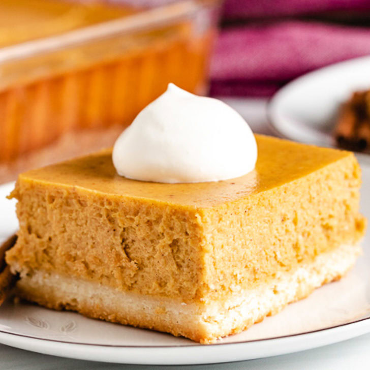 Square piece of pumpkin cheesecake on a plate.