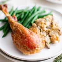 Roast turkey leg with green beans on a plate.