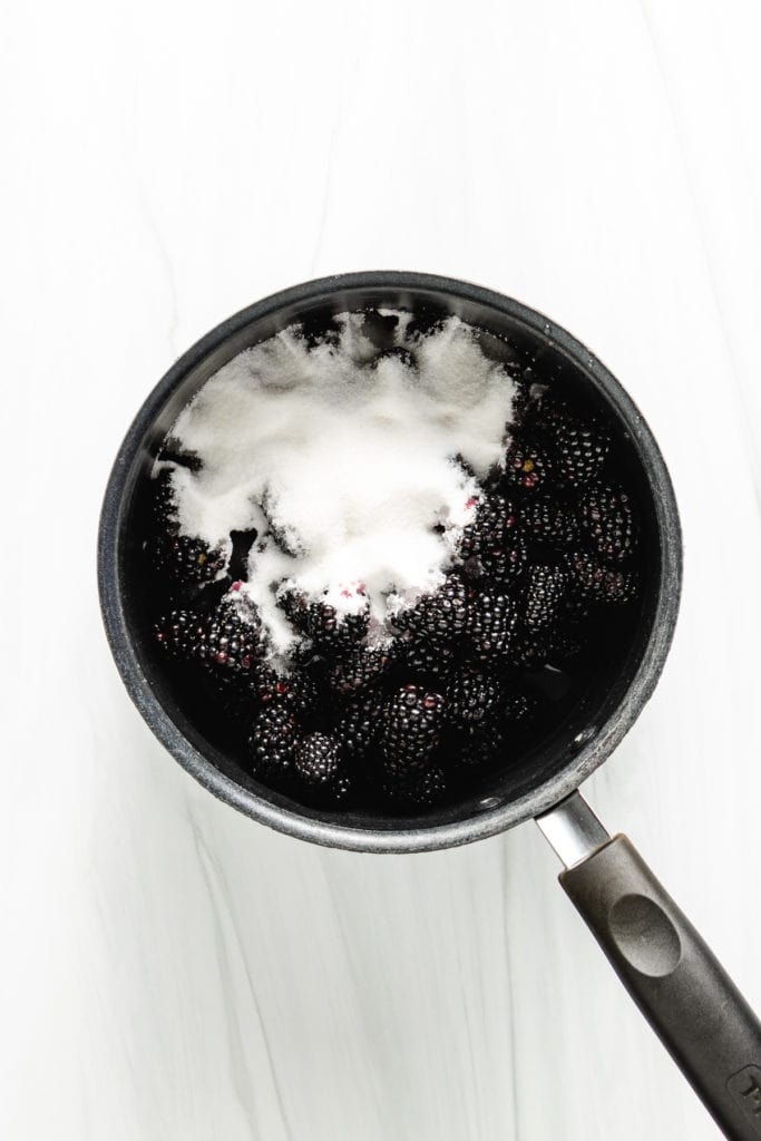 Blackberries, sugar, and water in a pan.