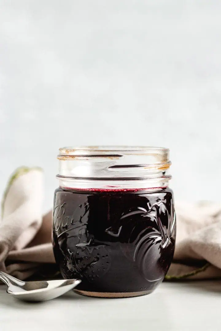 Side view of fruit syrup in a glass jar.