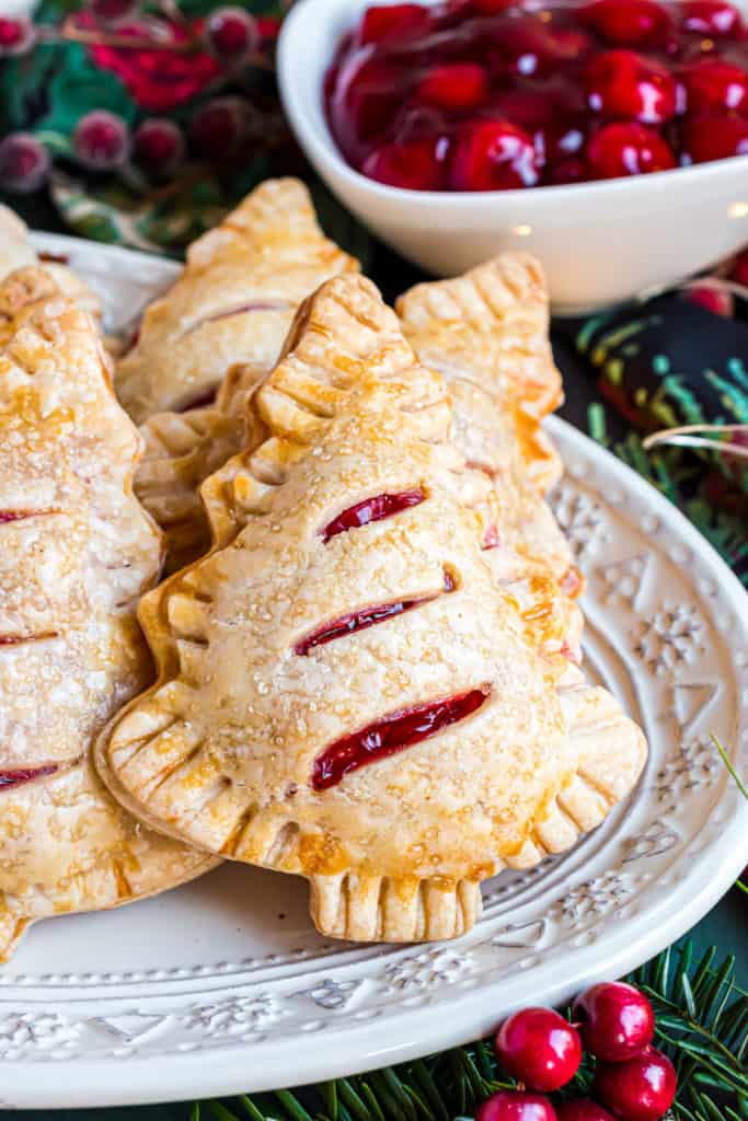 Close up view of several cherry hand pies on plates.