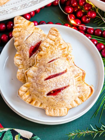 Two cherry hand pies on a white plate.