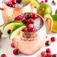 Two copper mugs filled with cranberry moscow mules.