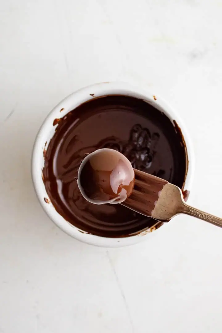 Dark Chocolate Peppermint Truffles Fork dipping a truffle into melted chocolate.