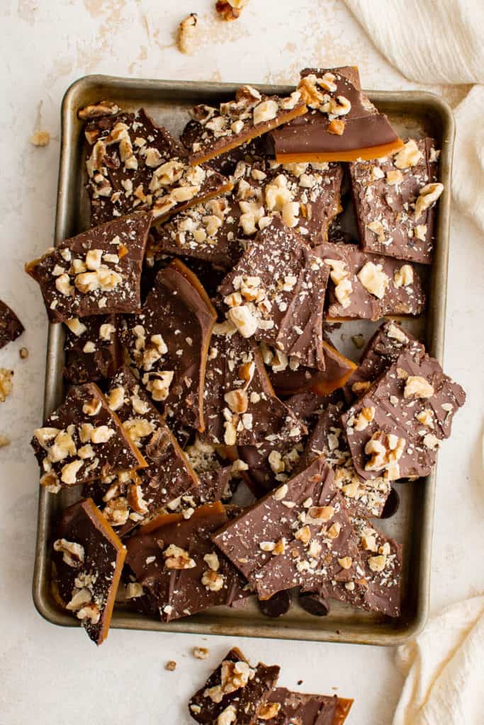 Top down view of English toffee topped with melted chocolate and nuts.