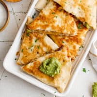 Several pieces of fajita quesadilla on a white platter.