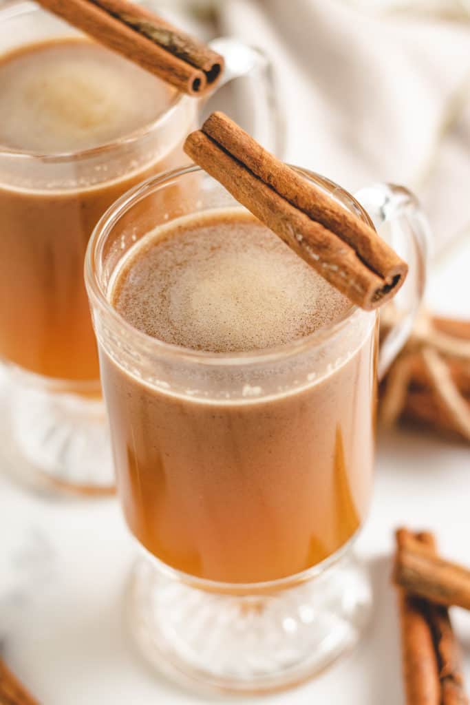 Top down view of two mugs of hot buttered rum.