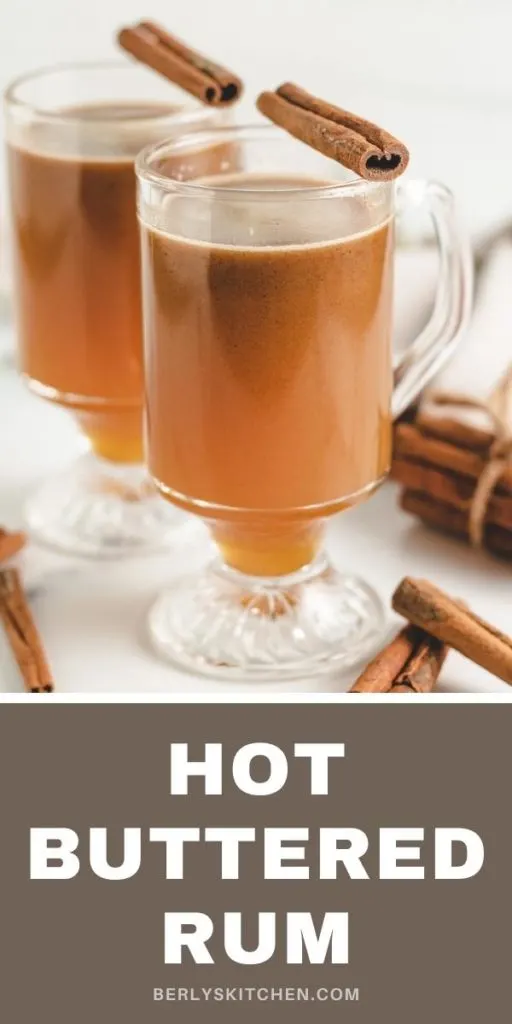 Two glasses of hot buttered rum with cinnamon sticks.